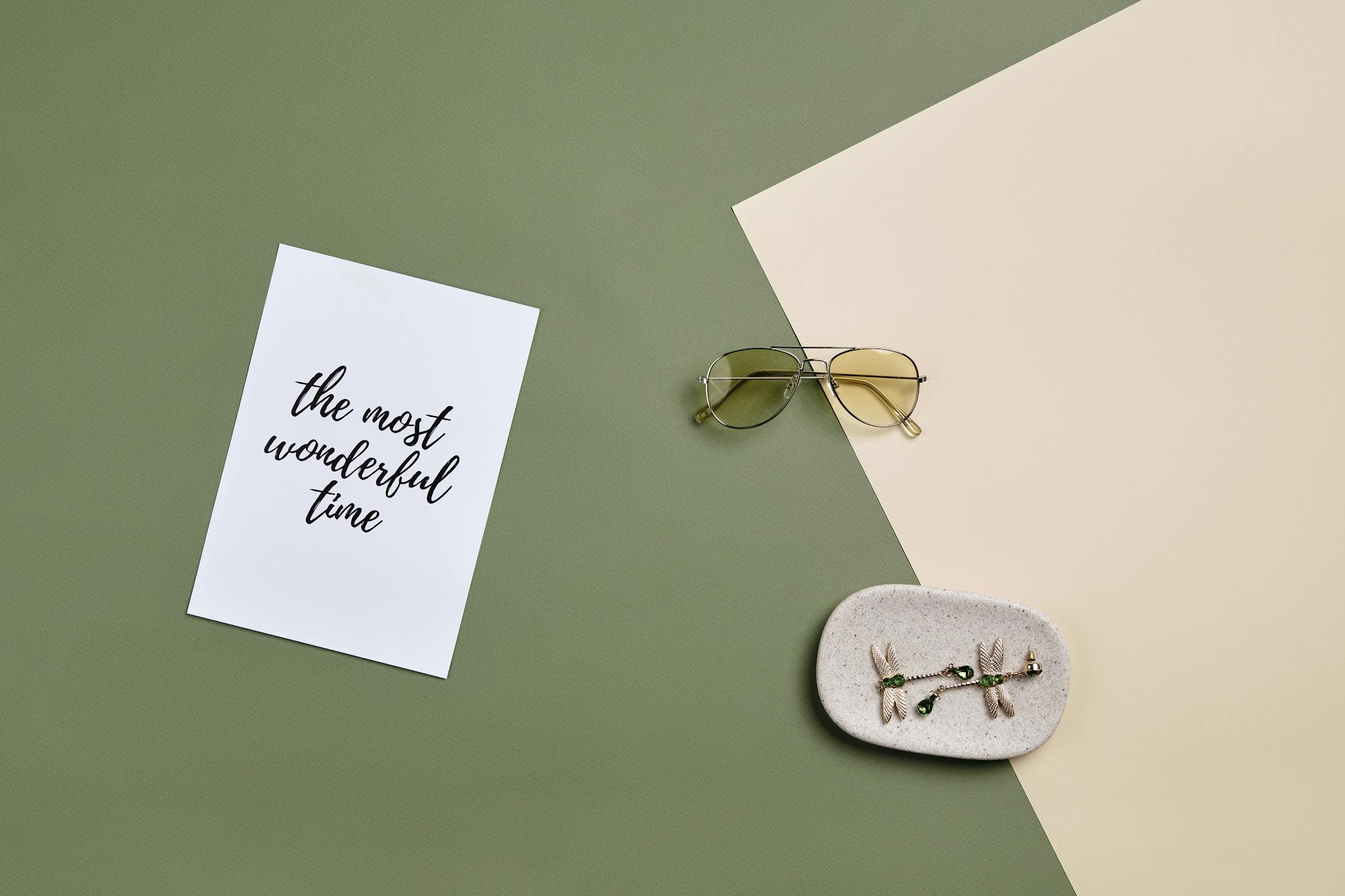 Minimalist flat lay featuring a card with 'the most wonderful time' and accessories.